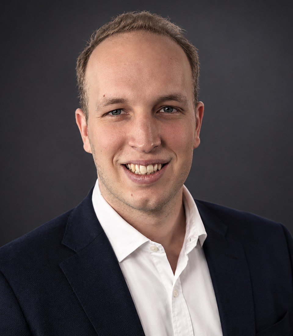 Lennard Kraft an seinem Arbeitsplatz vor der Monitorwand